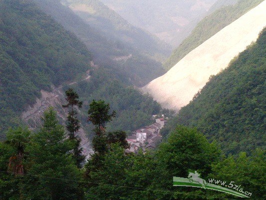 小镇后面的那条白色的山体，是因地震